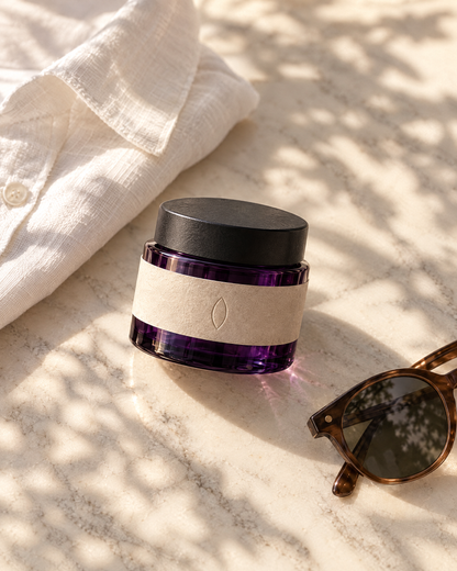 The day cream on marble in morning light beside a linen shirt and sunglasses